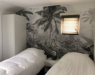 Tweede slaapkamer met palmbehang in Vakantiehuis Bikkel, Terschelling.