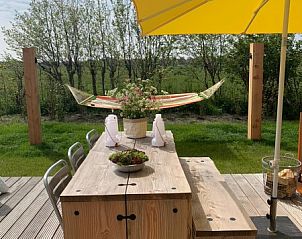 Buiten eettafel en parasol bij Sinne vakantiewoning in Midsland Noord Terschelling.