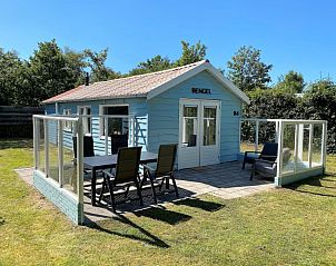 Buitenterras van Vakantiehuis Bengel in Midsland Noord, Terschelling met glazen omheining en tuin.