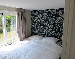 Slaapkamer in Vakantiehuis Bengel, Midsland Noord, Terschelling met uitzicht op de tuin.