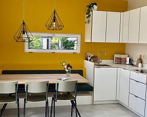 Gezellige keuken in Buitenhuis chalet, Midsland Noord, Terschelling met gele muur en eetruimte.