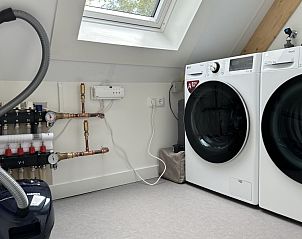 Wasruimte in Vakantiehuis Schavuit, Midsland Noord, Terschelling, met moderne wasmachine en droger.