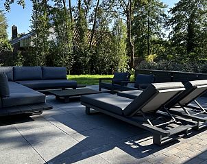 Ruim terras van Vakantiehuis Schavuit, Midsland Noord, Terschelling, met luxe ligstoelen.