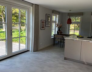 Eetkamer en keuken in Vakantiehuis Deugniet, Midsland Noord, Terschelling, met tuinzicht.