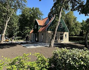 Buitenkant van Vakantiehuis Deugniet in Midsland Noord, Terschelling, omgeven door groen.