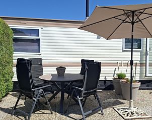Zonnig terras met parasol bij Moai Fuort stacaravan, Midsland Noord, Terschelling.