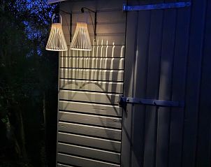 Buitenruimte met tuinset en parasol bij Moai Fuort stacaravan, Midsland Noord, Terschelling.