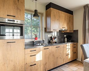 Modern kitchen in vacation home De Dijkwachter, Ballum, Ameland, with wooden finish and all conveniences.