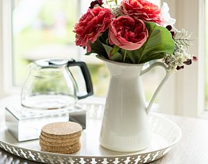 Decorative flowers on the table at De Dijkwachter, vacation home in Ballum, Ameland, for a homely atmosphere.