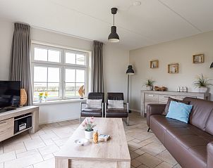 Bright living room of De Dijkwachter, Ballum, Ameland, with modern furniture and relaxing atmosphere.