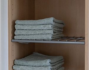 Tidy closet with towels in De Dijkwachter, vacation home in Ballum, Ameland.