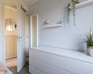 Modern bedroom with dresser in De Dijkwachter, Ballum, Ameland, for a restful night's sleep.
