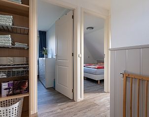 Hallway with storage in De Dijkwachter, Ballum, Ameland, with access to bedrooms.