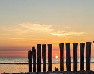 Wooden poles at sunset on the beach of Ameland.