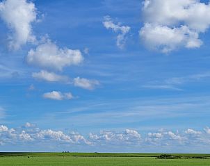 Vast green fields and blue sky at Holiday Home in Ballum, Ameland.