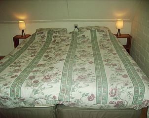 Knusse slaapkamer in vakantiehuis elsbeth.op-ameland, Ballum, Ameland met tweepersoonsbed en sfeervolle verlichting.