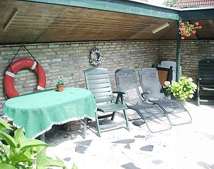 Overdekt terras bij elsbeth.op-ameland vakantiehuis in Ballum, Ameland met comfortabele ligstoelen en tafel.