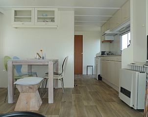 Gezellige eetruimte in Eilandgeluk chalet, Ballum, Ameland met moderne keuken en houten vloer.