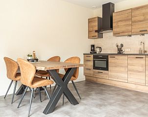 Eethoek in Storm Ameland appartement, Ballum, met stijlvol houten interieur.