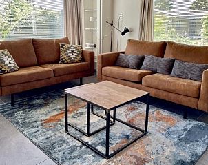 Gezellige woonkamer in Esti vakantiehuis, Ballum, Ameland met comfortabele banken.