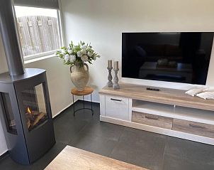 Stijlvolle hoek met open haard en televisie in Tree Lodge, Ballum, Ameland.