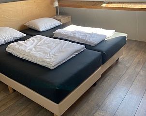 Lichte slaapkamer met tweepersoonsbed in Tree Lodge, Ballum, Ameland.