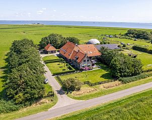 Luchtfoto van Tree Lodge, Ballum, Ameland omringd door groene velden.