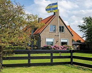Vooraanzicht van Tree Lodge, Ballum, Ameland met kleurrijke bloemen.