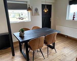 Eethoek met houten tafel in appartement Fleurie, Ballum, Ameland, perfect voor gezellige maaltijden.