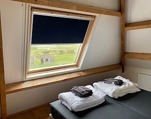 Uitzicht vanuit de slaapkamer van appartement Fleurie in Ballum, Ameland, met veel natuurlijk licht.