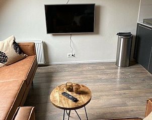 Petit appartement in Ballum, Ameland, met flatscreen-tv en gezellige sfeer, ideaal voor ontspanning na een dag verkennen.