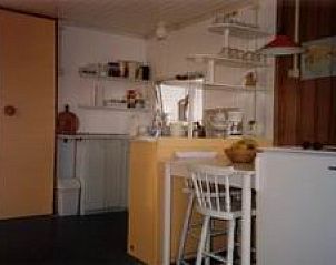 Cozy indoor area of mobile home in Ballum, Ameland with kitchen and dining area, perfect for a relaxing stay.