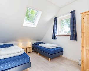 Ruime slaapkamer met twee eenpersoonsbedden in Weigelia, Ballum, Ameland met veel natuurlijk licht.
