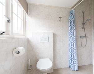 Stijlvolle douche in Weigelia vakantiehuis, Ballum, Ameland met moderne tegels en veel daglicht.