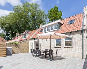 Ruim terras bij Weigelia vakantiehuis, Ballum, Ameland met tuinset en parasol, perfect voor buiten dineren.