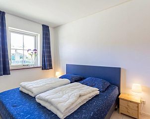 Sfeervolle slaapkamer in vakantiehuis Linde, Ballum, Ameland met tweepersoonsbed op de Waddeneilanden.