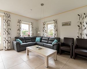 Lichte woonkamer van vakantiehuis Hazelaar, Ballum, Ameland met grote ramen.