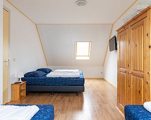 Grote slaapkamer met houten vloer in vakantiehuis Hazelaar, Ballum, Ameland.