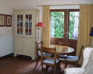 Gezellige eetruimte in Akkerduin vakantiehuis in Ballum, Ameland met houten meubels.