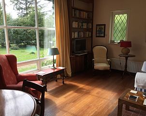 Lichte woonkamer in Akkerduin vakantiehuis in Ballum, Ameland met grote ramen.