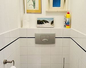 Knusse slaapkamer met houten meubels in Akkerduin vakantiehuis in Ballum, Ameland.