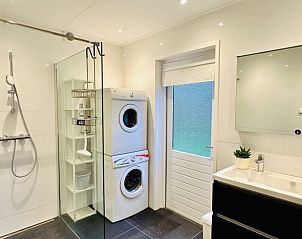 Moderne badkamer met wasmachine in Akkerduin vakantiehuis in Ballum, Ameland.