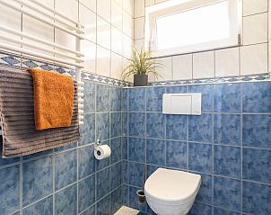 Moderne badkamer met blauwe tegels in Arcoz vakantiehuis, Ballum, Ameland.