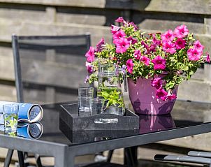 Terras met bloemen en drankjes bij Arcoz vakantiehuis, Ballum, Ameland.