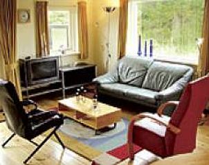 Gezellige woonkamer in De Ouwe Pol bungalow, Buren, Ameland met comfortabele zitruimte en natuurlijk licht.