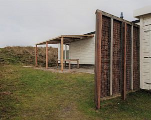 Exterieur van Strandjutter G2, chalet in Buren, Ameland, met houten terras en natuurlijke omgeving.
