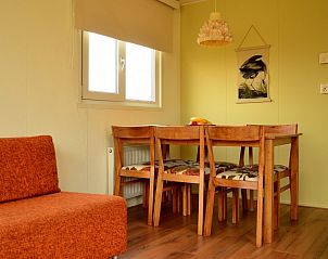 Eethoek van Strandjutter G2, vakantiehuis op Ameland, met houten meubels en vrolijke decoratie.