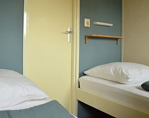 Slaapkamer met twee eenpersoonsbedden in Strandjutter G2, vakantiehuis op Ameland, voor een goede nachtrust.