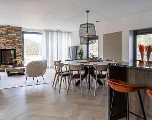 Ruime woonkamer in vakantiehuis MIEKIE, Buren, Ameland met open haard en moderne inrichting.