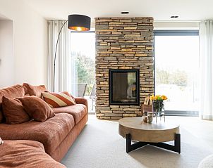 Comfortabele zithoek in vakantiehuis MIEKIE, Buren, Ameland met uitzicht op de tuin.